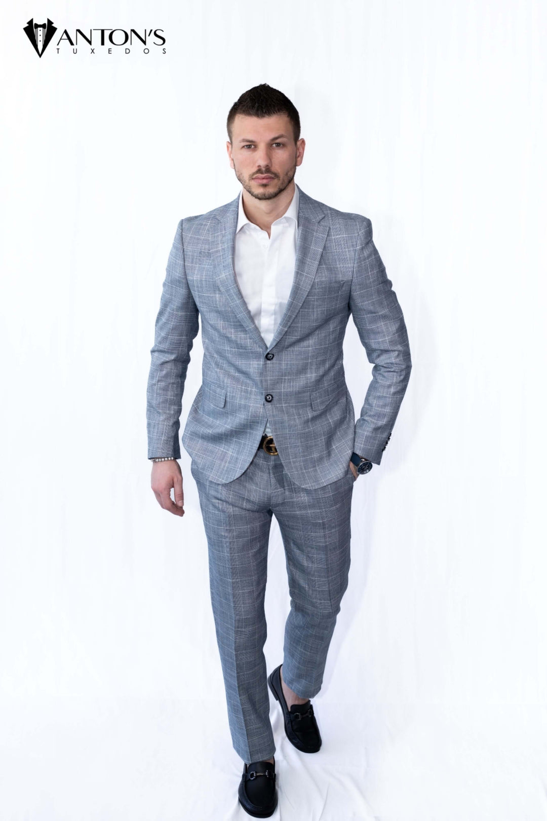 Man wearing a gray checkered suit made from 100% Italian wool, perfect for wedding tuxedos, formal menswear, groom attire, and black tie weddings.