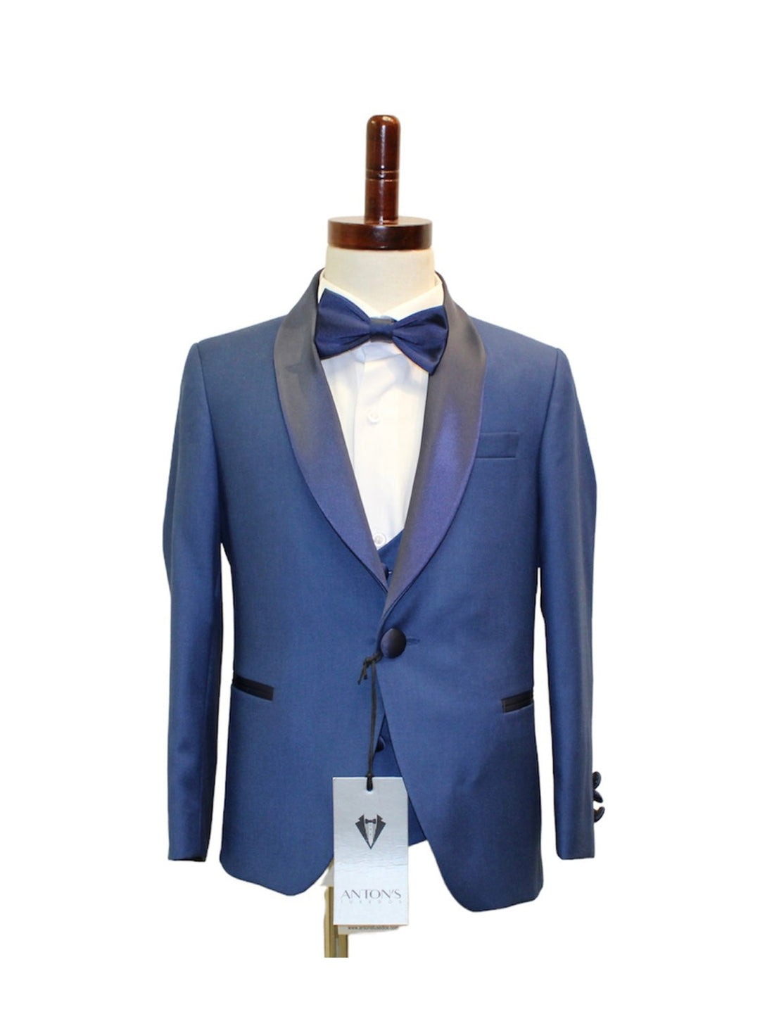 Blue kids tuxedo with bow tie and white shirt on mannequin, high-quality fabric, slim fit, perfect for special occasions.