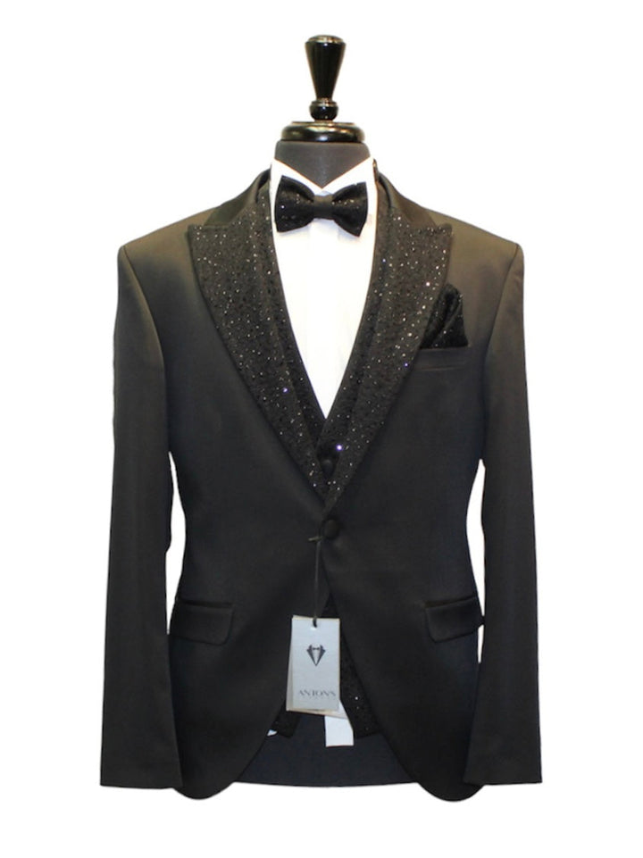 Black tuxedo with sparkly black lapels, shiny black vest, pants, and bow tie on a mannequin. Made of polyester, viscon, and elastan.